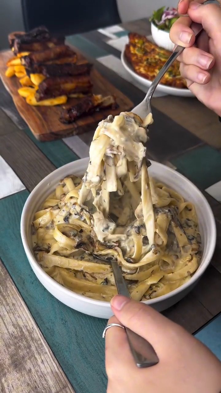 The original phone photo: a bowl of mushroom pasta on a café table, lit by whatever light was in the room.
